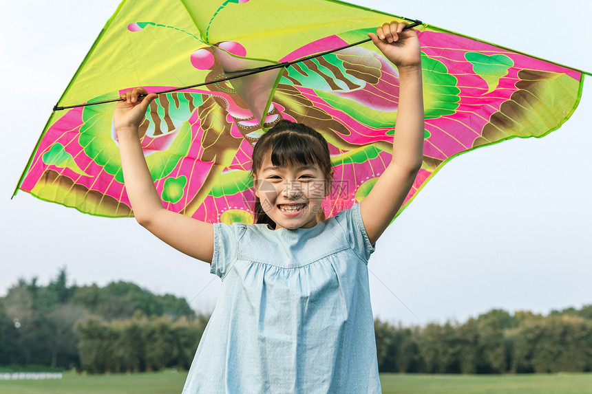 女孩在草坪玩风筝图片