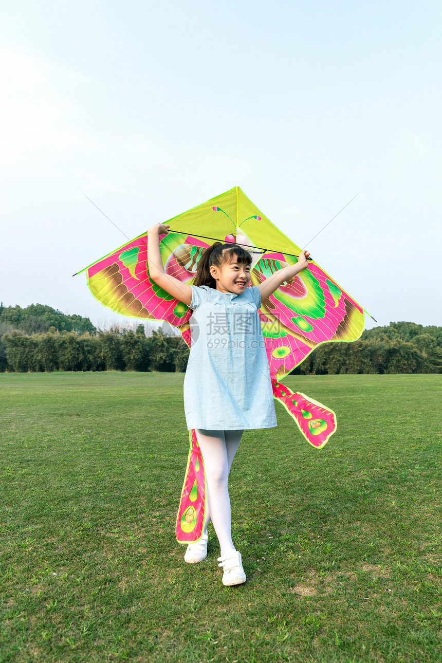 女孩在草坪玩风筝图片