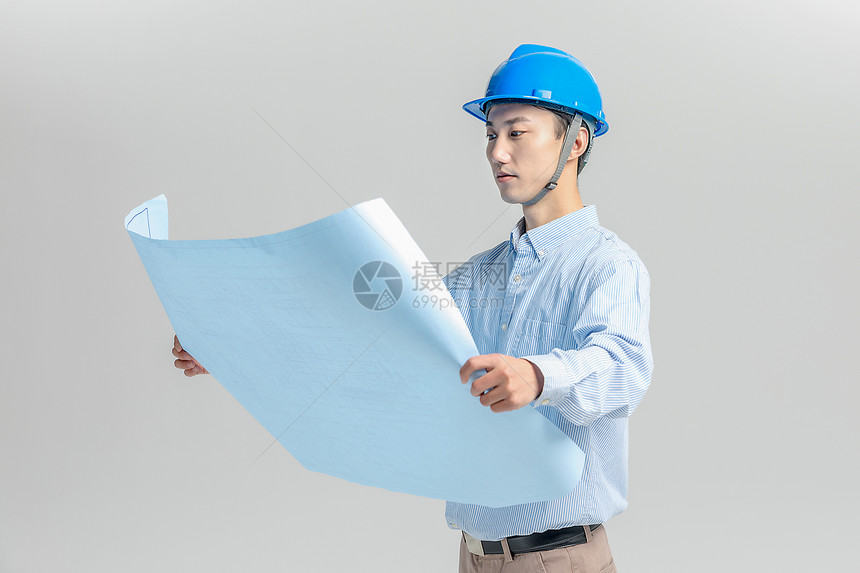 头戴安全帽看图纸的工程师图片