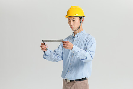 戴安全帽拿测量尺的工程师图片