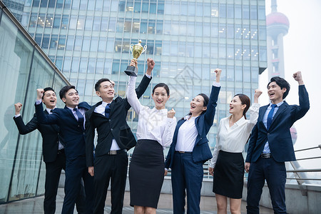 开心的商务人士企业团队举奖杯庆祝背景