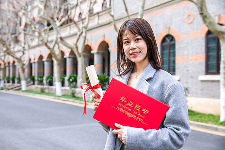 手拿盒子女大学生手拿毕业证书背景