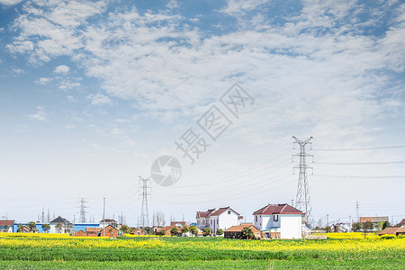 电力建设蓝天下的房屋农田和电网背景