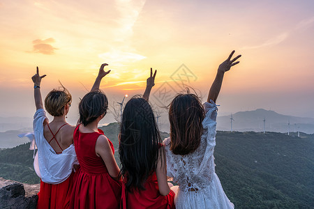 山顶黄昏山顶看日落的四个女生背影背景