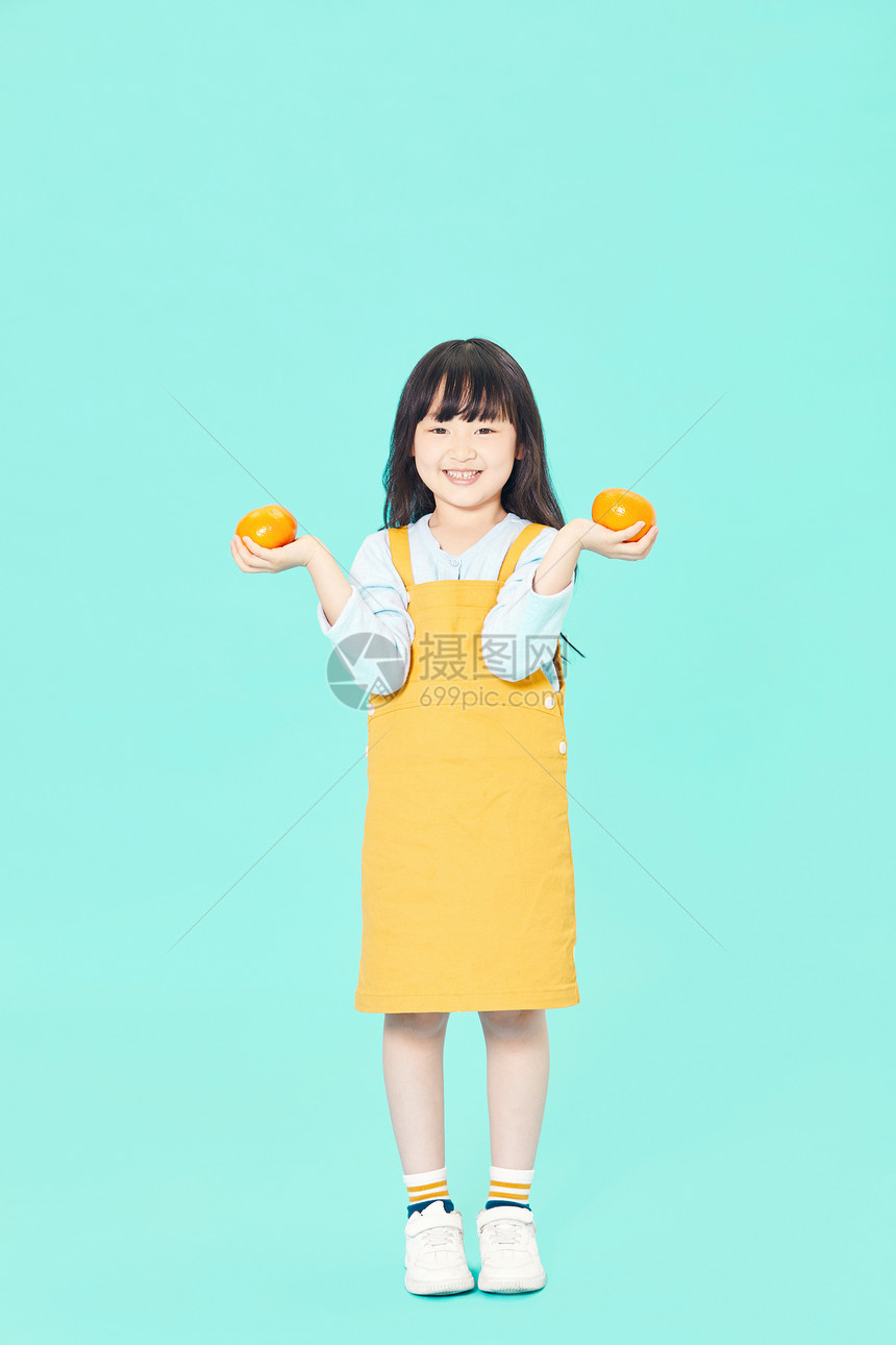 小女孩拿橙子图片