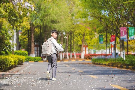 小男孩放学踢足球背景图片