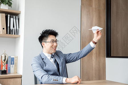商务男性办公室玩纸飞机图片