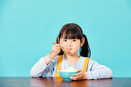 小女孩大口吃米饭高清图片