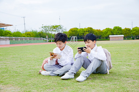 小学生操场玩手机高清图片