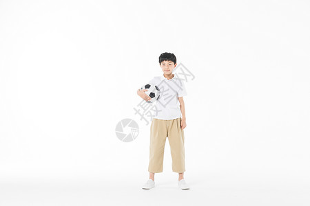 小男孩拿足球背景图片