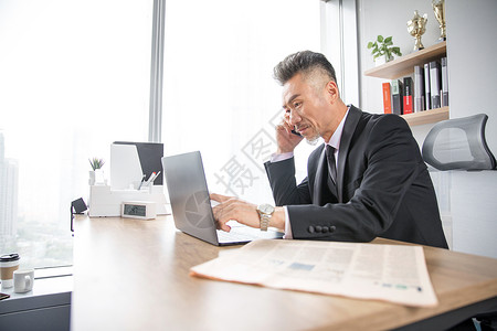 商务男士看电脑打电话图片