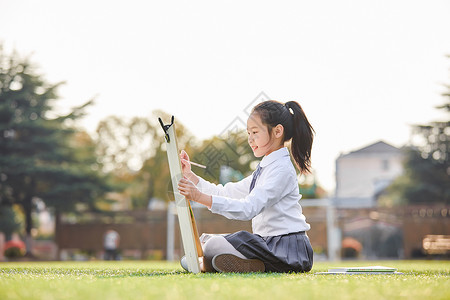 吹着口琴孩子小学生操场上画画背景