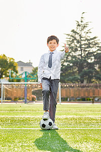 小学生操场踢足球背景图片
