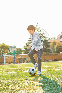 小学生操场踢足球背景图片