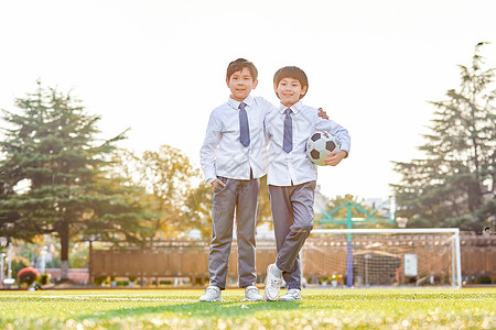 小学生操场踢足球背景图片