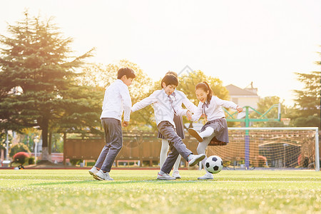 小学生操场踢足球背景图片