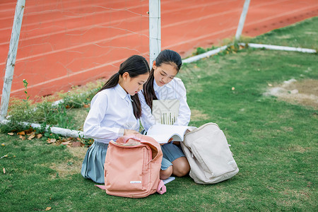 穿校服的女同学小学生操场看书背景