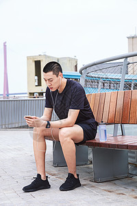 运动男性休息玩手机图片