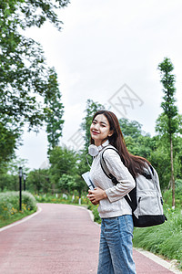 抱着书女同学背着书包抱着书本的女学生背景