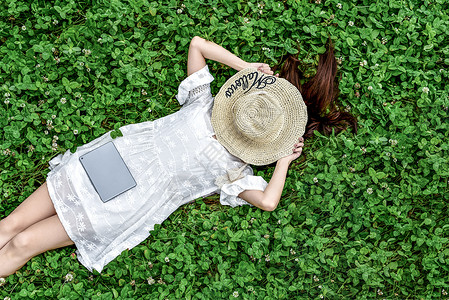 女孩戴帽子躺在草地戴帽子的女孩背景
