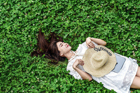 躺在草坪晒太阳的女孩背景图片