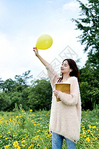 抱着书本手拿气球的女生图片