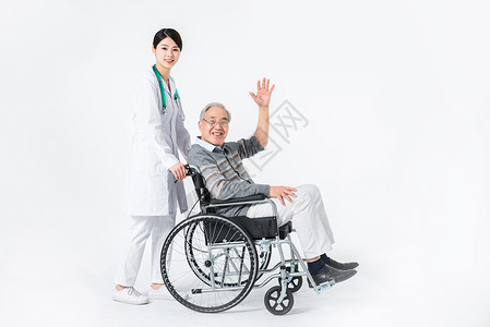挥手的老人轮椅老人与护工背景