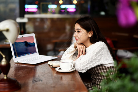 美女坐着喝咖啡玩电脑背景图片