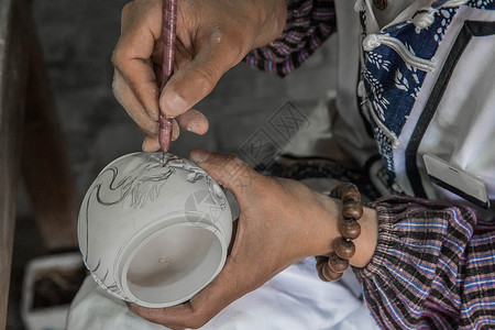 陶瓷水壶正在花瓶上雕刻的匠人背景