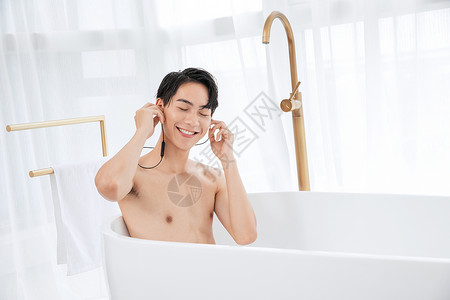 年轻男子泡澡听音乐背景图片