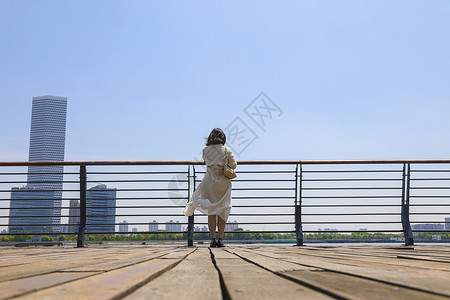 江边休闲一个在江边观赏风景的女人背影背景