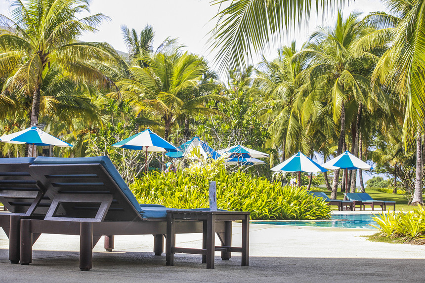 泰国度假酒店泳池边的躺椅和遮阳伞图片