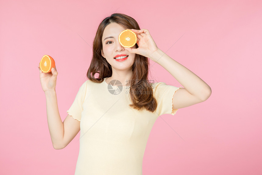 青年女性拿着橙子图片