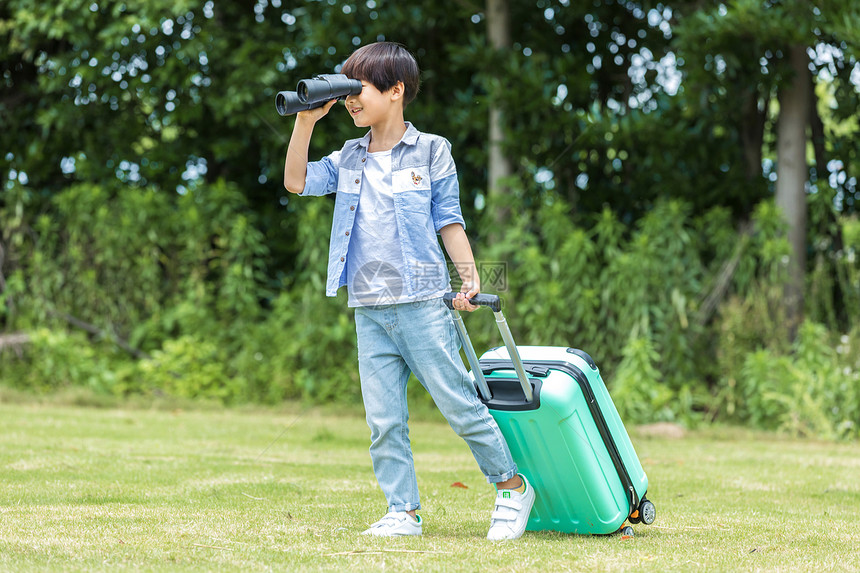 小男孩草地旅行箱望远镜图片