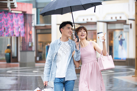 下雨打伞情侣情侣下雨逛街购物背景