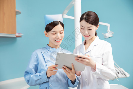 医院女性牙科医生和护士讨论工作背景