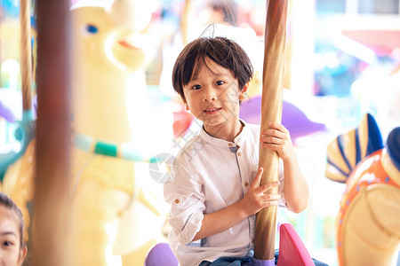 小男孩在游乐场坐旋转木马图片