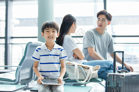 候车男孩一家三口机场候车玩平板电脑背景