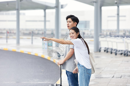 行李旅游情侣在机场外打车背景