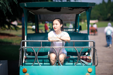 女孩坐公园游览车背景图片