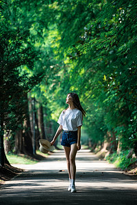 女孩走在林荫小道上高清图片