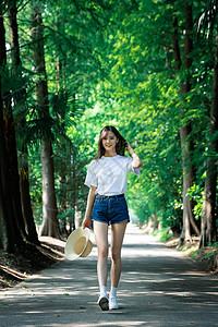 女孩走在林荫小道上高清图片