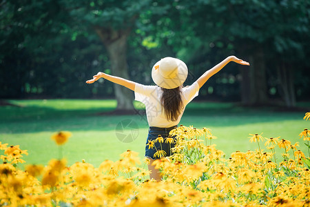 花海戴帽子女性背影高清图片