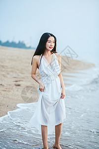 提着裙摆的海边女孩背景图片
