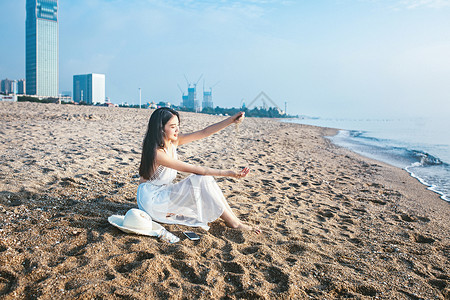 沙滩玩沙子美女背景