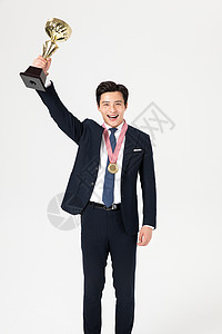 商务男性举起奖杯图片