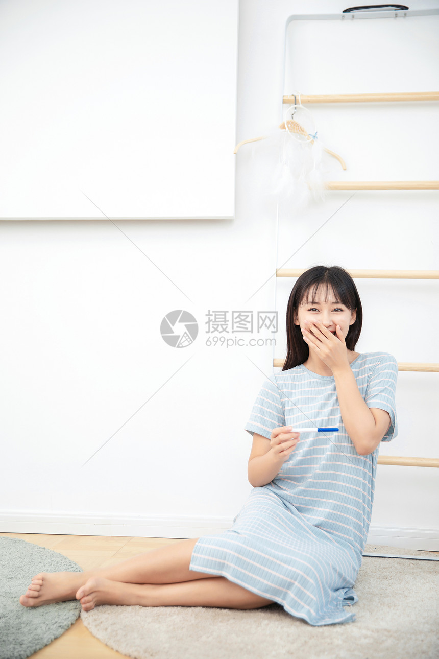 女生在卧室看到验孕结果很惊喜图片