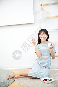 美女在卧室地毯上坐着喝牛奶图片