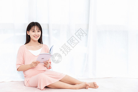 孕妇读书孕妇在纱窗旁边侧腿坐着看书阅读背景