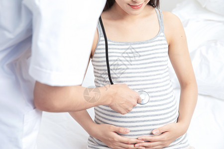 腹中胎儿家庭医生在卧室给孕妇做定期检查背景